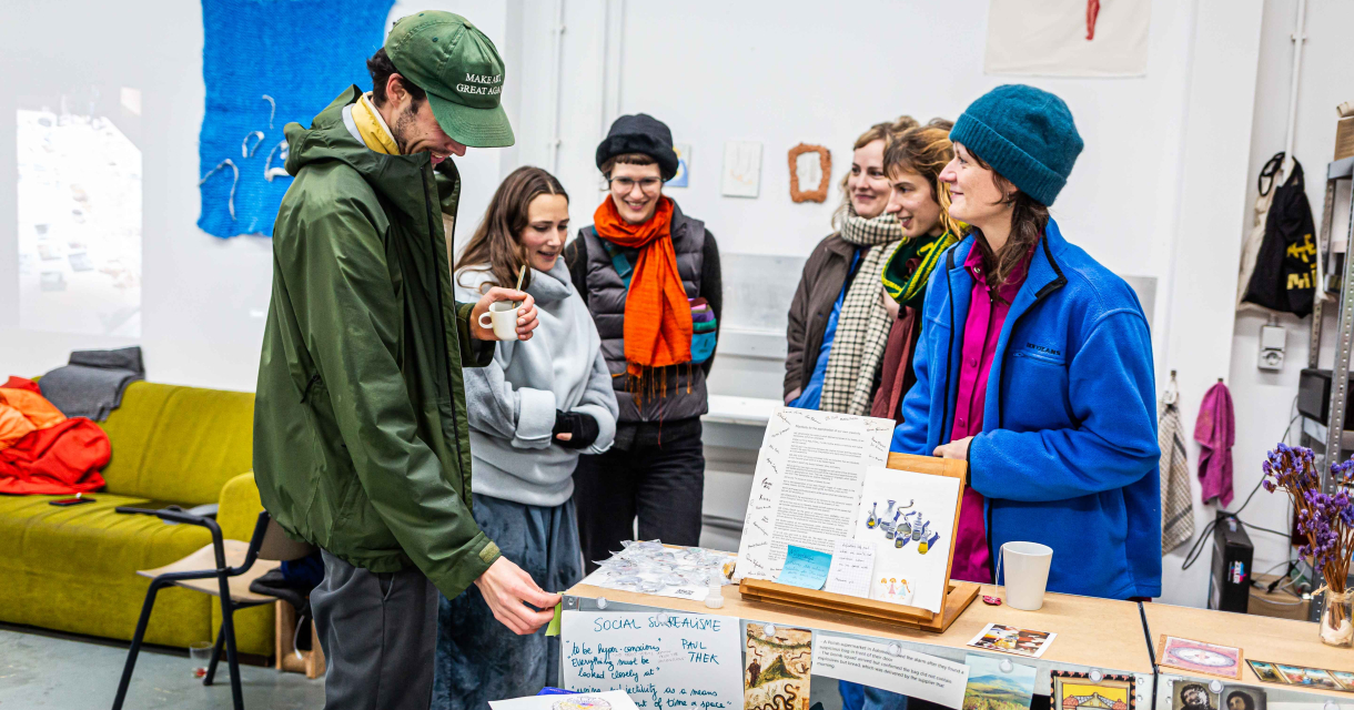 Een man en vrouwen in een creatieve omgeving met kunstwerken