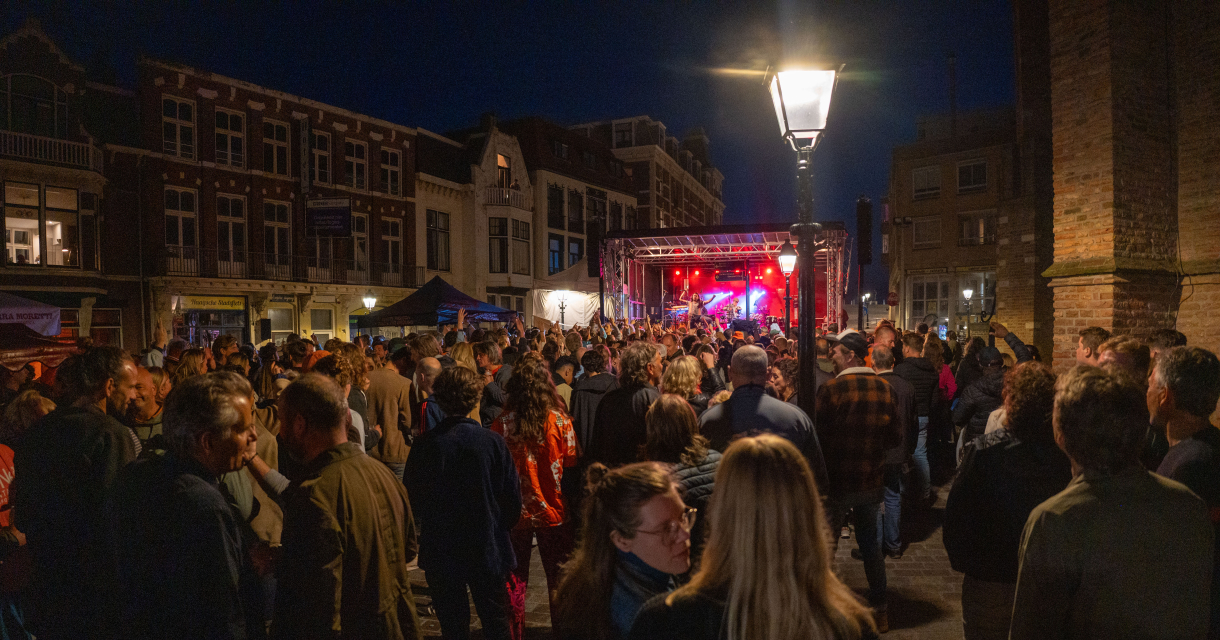 Een drukke menigte geniet van een concert in de Keizerstraat Scheveningen bij nacht. Foto: Iwan de Brabander