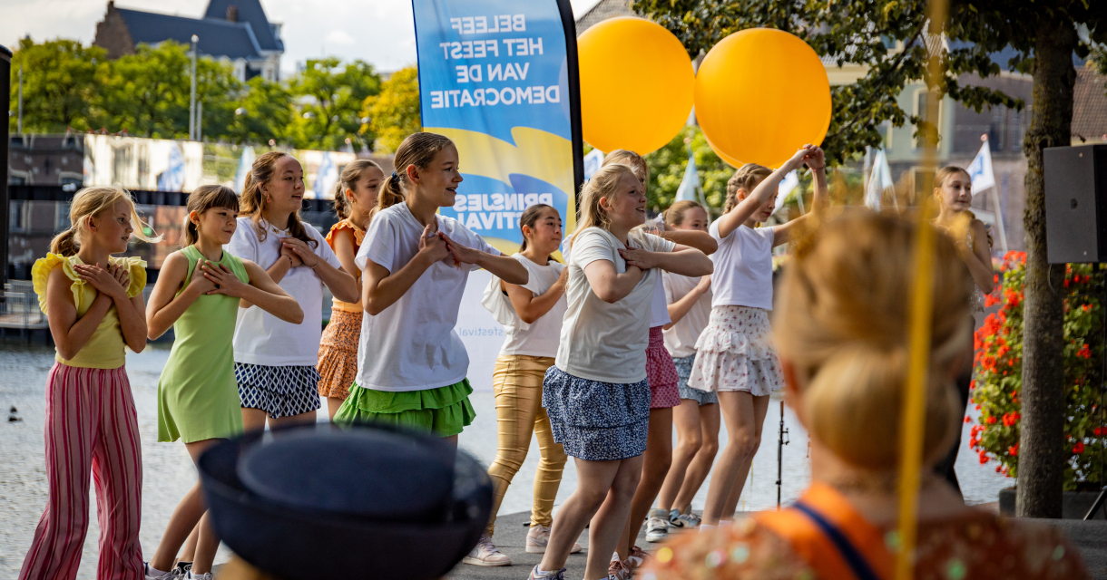 Meisjes dansen met ballonnen nabij de Hofvijver.
