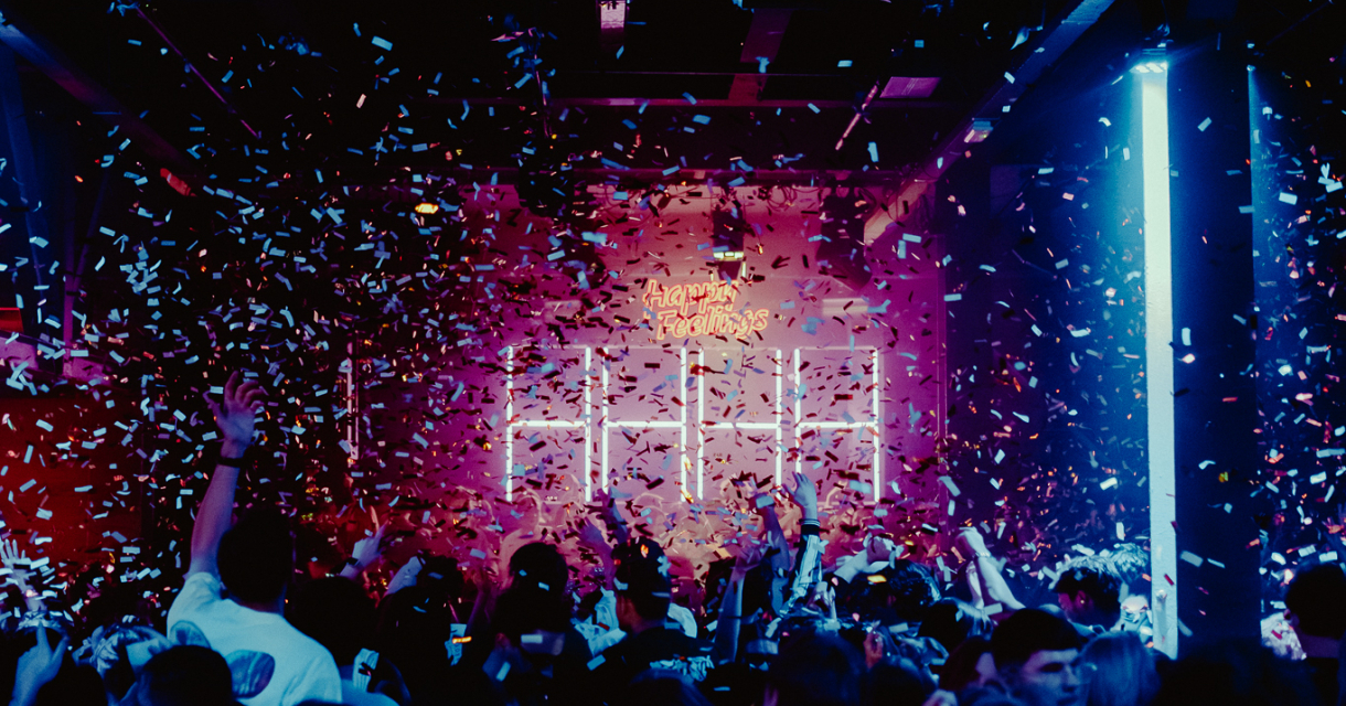 Een druk feest met mensen die confetti in de lucht werpen.