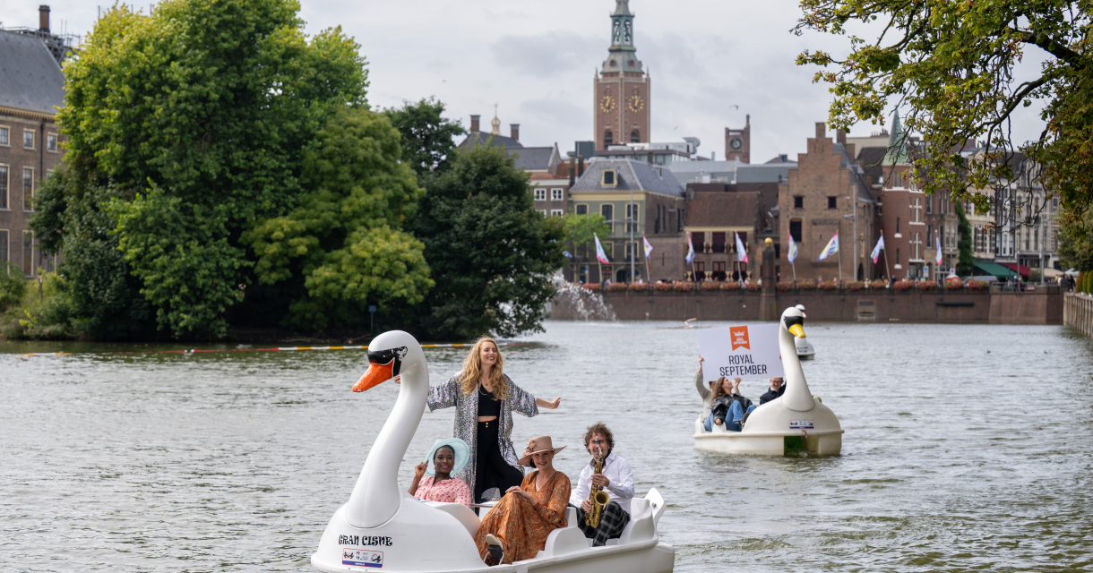 Groep mensen in zwanenboten op de Hofvijver