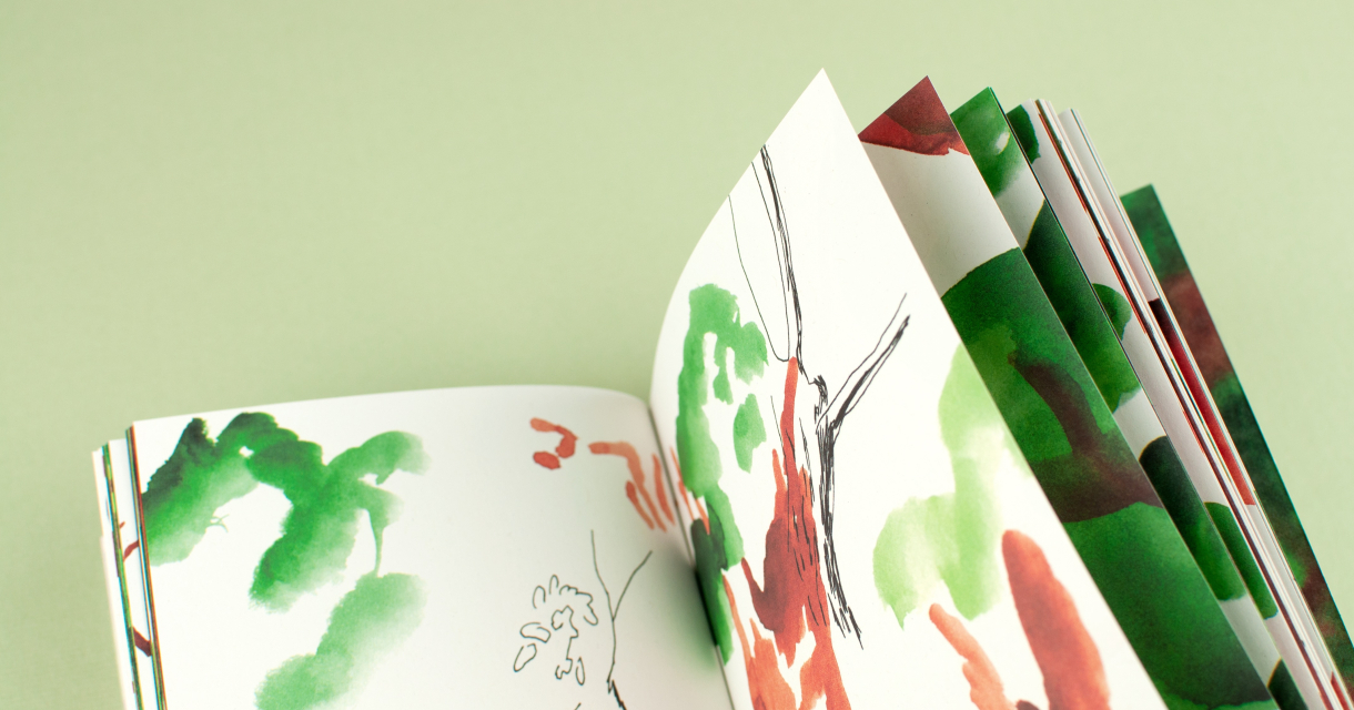 Tentoonstelling Omslag. Een geopend schetsboek met groene en rode aquarellen van bomen en takken.