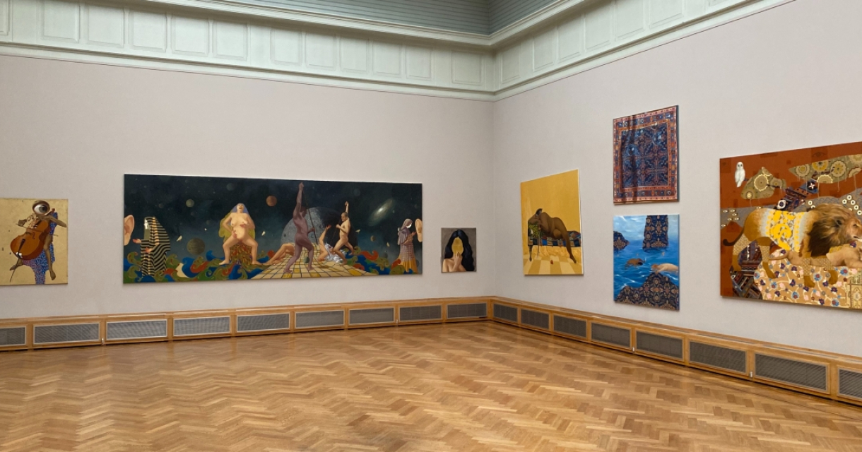 Interieur van een museum met diverse schilderijen aan de muur
