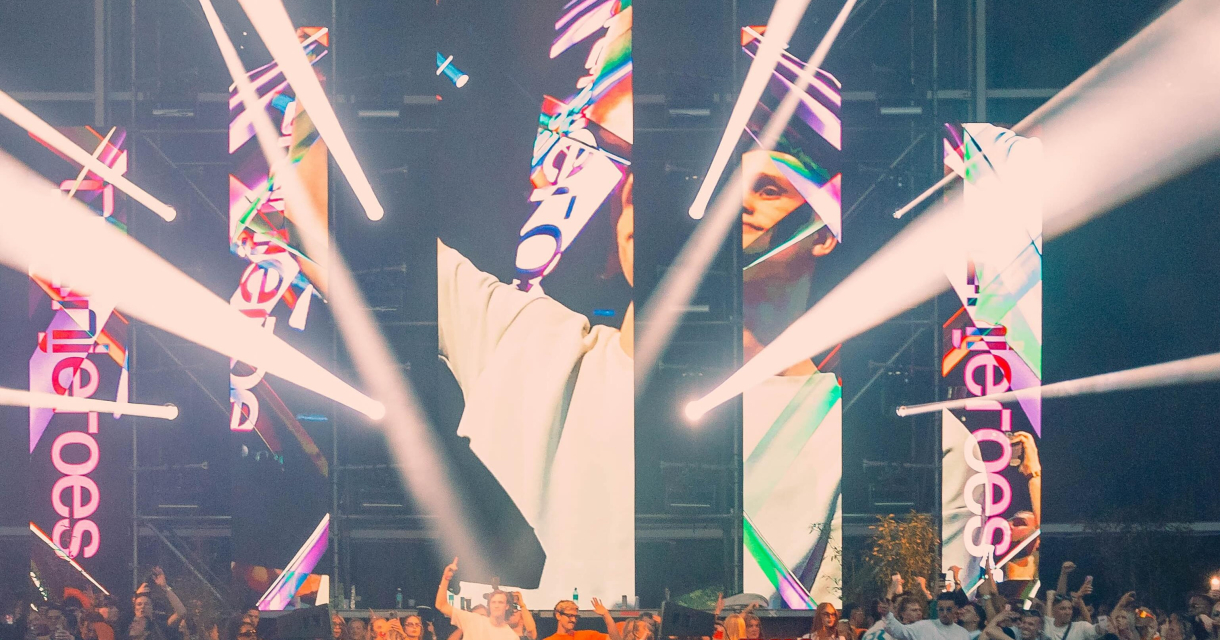 Een druk dansfeest met een DJ en lichtshow.