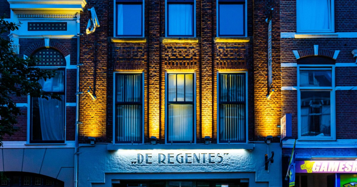 Het gebouw van Theater De Regentes met verlichting in de avond.