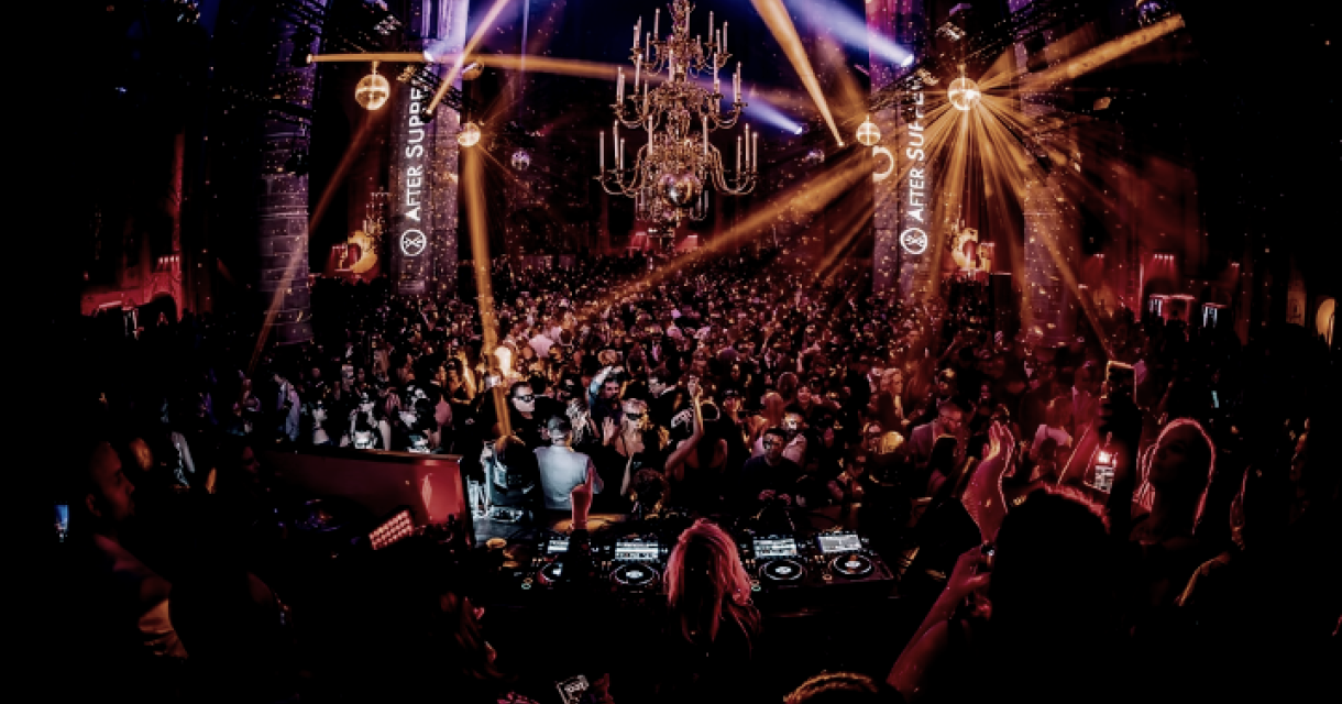 Crowded party venue with dancing people and light shows