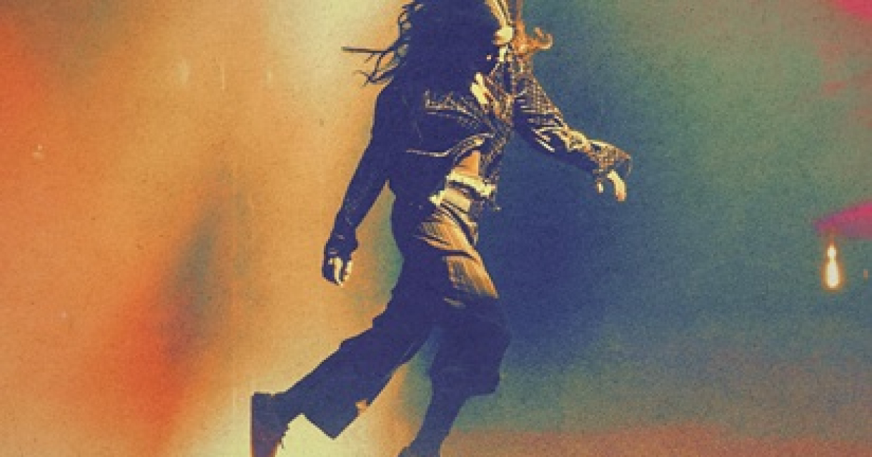 Iemand in een dynamische dansbeweging met kleurrijke achtergrond.