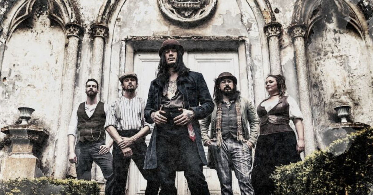 Een band staat voor een vervallen gebouw, gekleed in vintage stijl. Photo-by-Daphyd-Sense