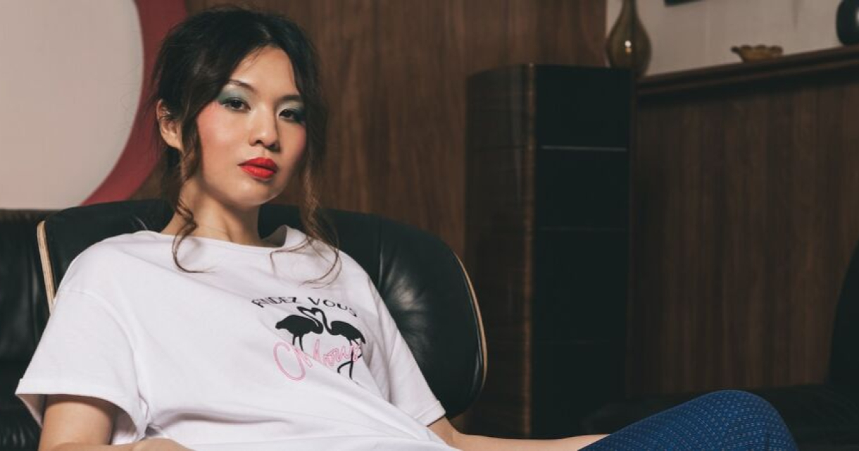 Young woman in a T-shirt sitting on a couch