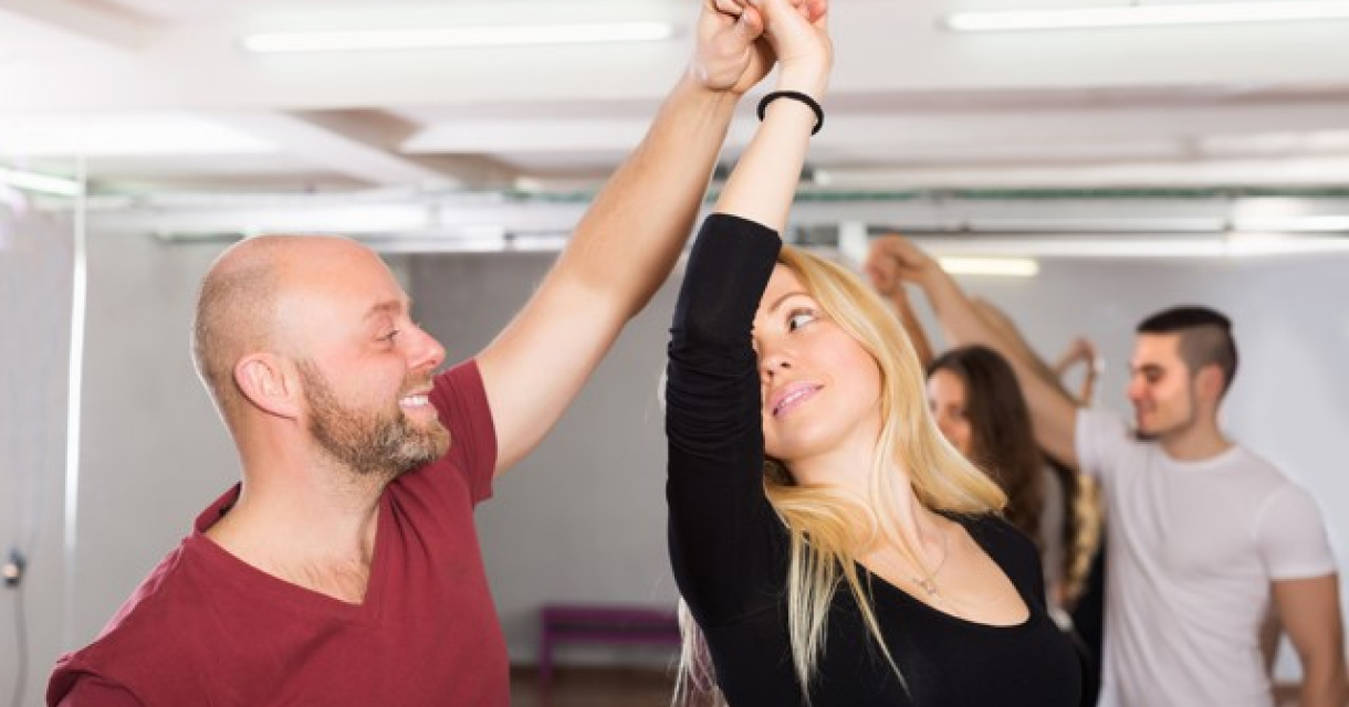 A man and woman dancing together in a studio.