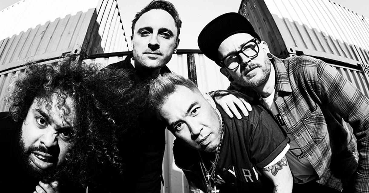 Vier muzikanten van Call it Off poseren voor een containerwand in zwart-wit.