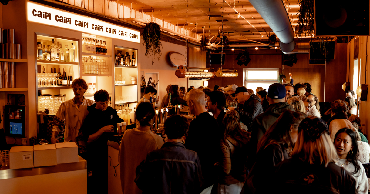 Busy bar, warm mood lighting and surf decorations on the ceiling