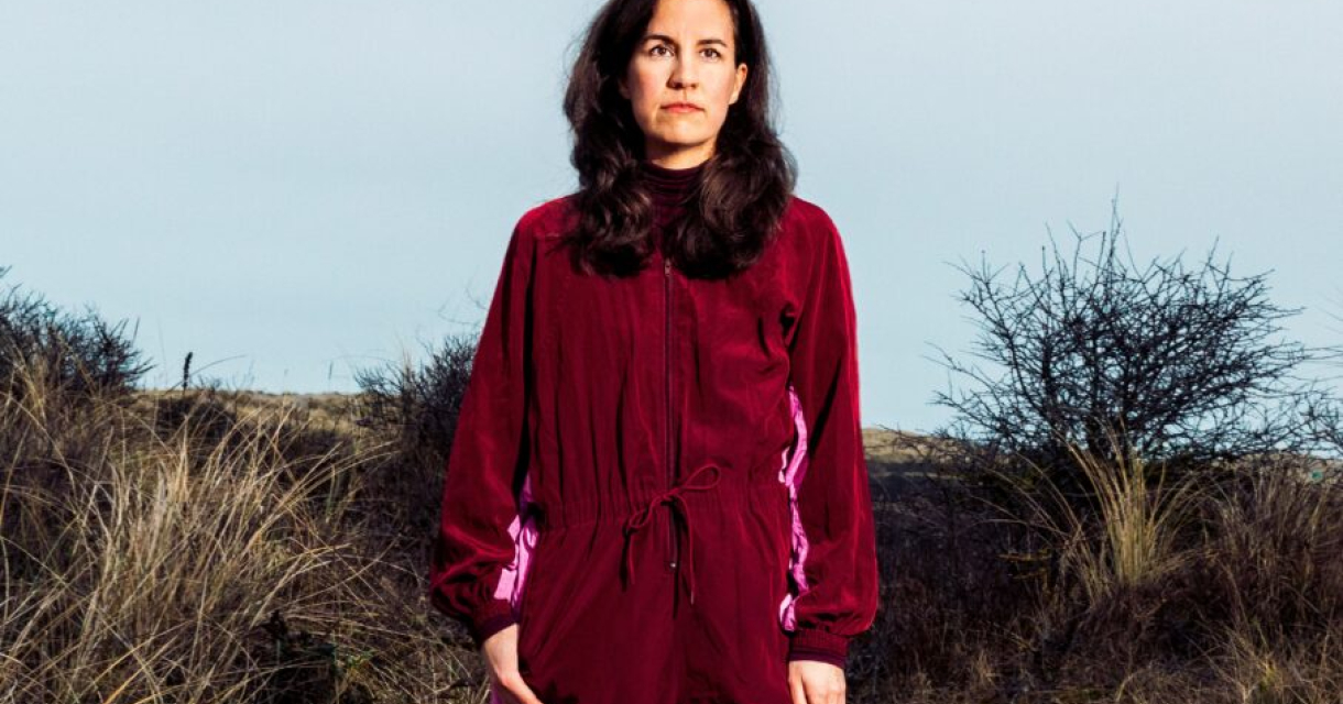 Vrouw met lange haren staat in duingras