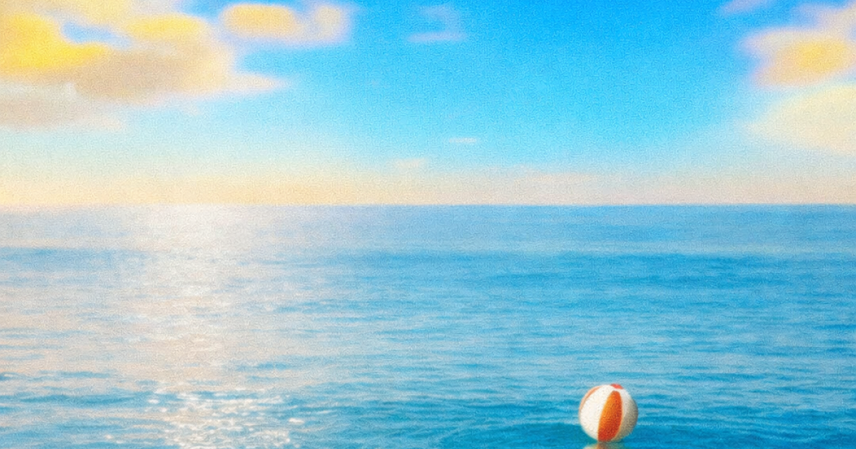 Een opblaasbare bal drijft op water onder een blauwe lucht.