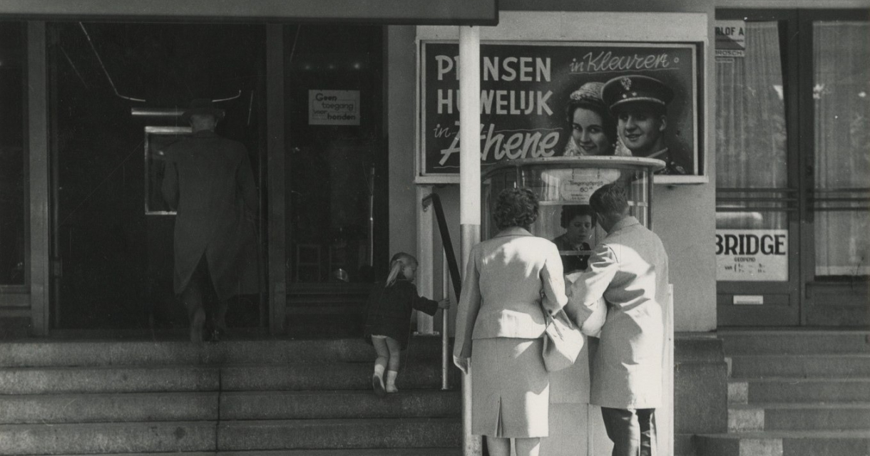 Drie mensen staan bij een bioscoopkasje in Den Haag.
