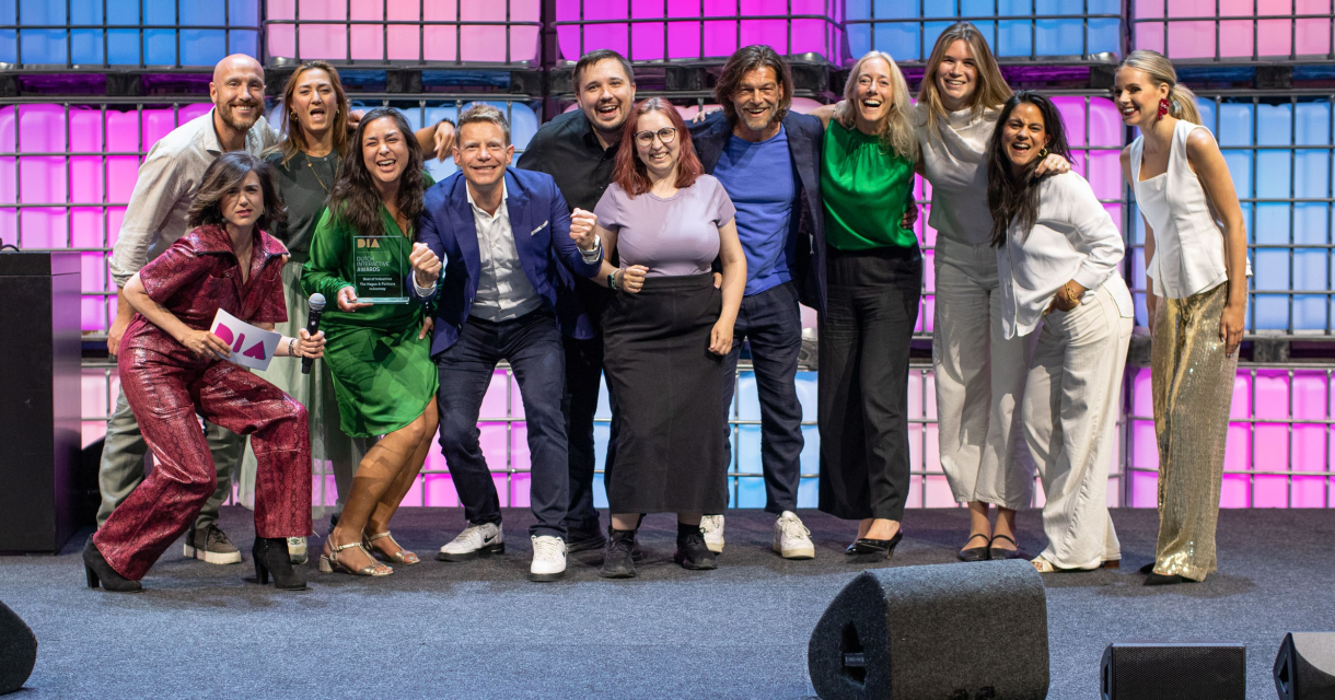 Een groep mensen poseert blij op een podium.