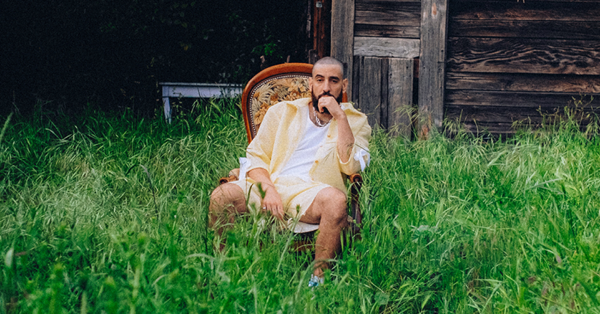 Een man zit pensioenerend in een stoel, omringd door hoog gras.