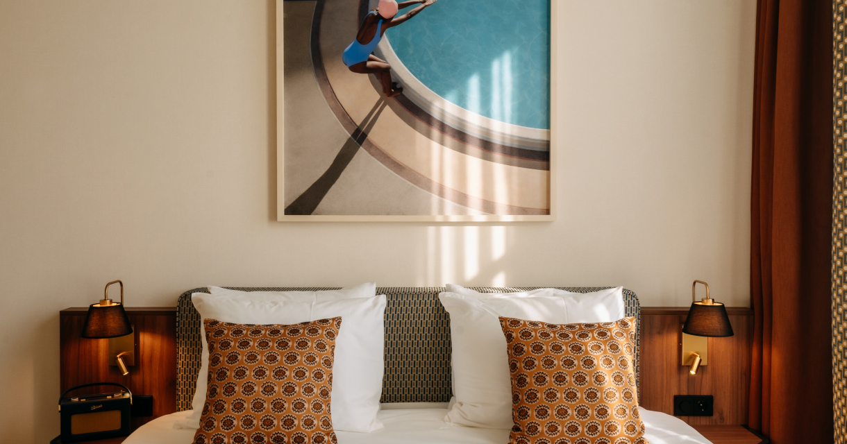 Deluxe Double Room met een bed met daarop kussens en warme houten accenten