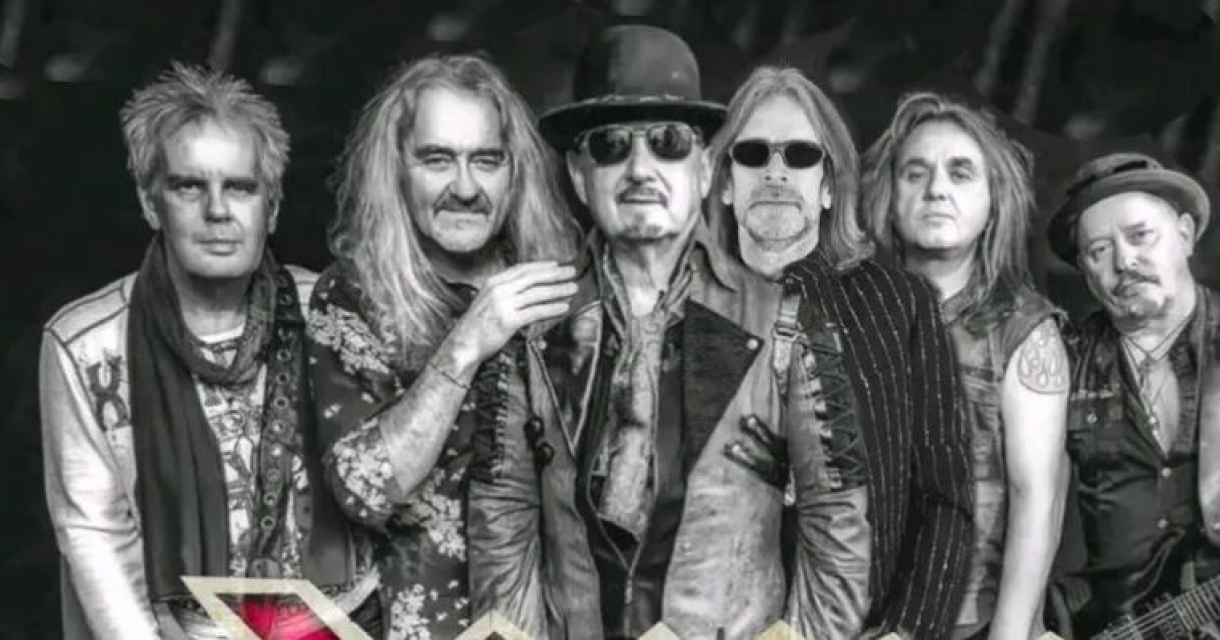 Zes bandleden poseren samen in zwart-wit stijl.