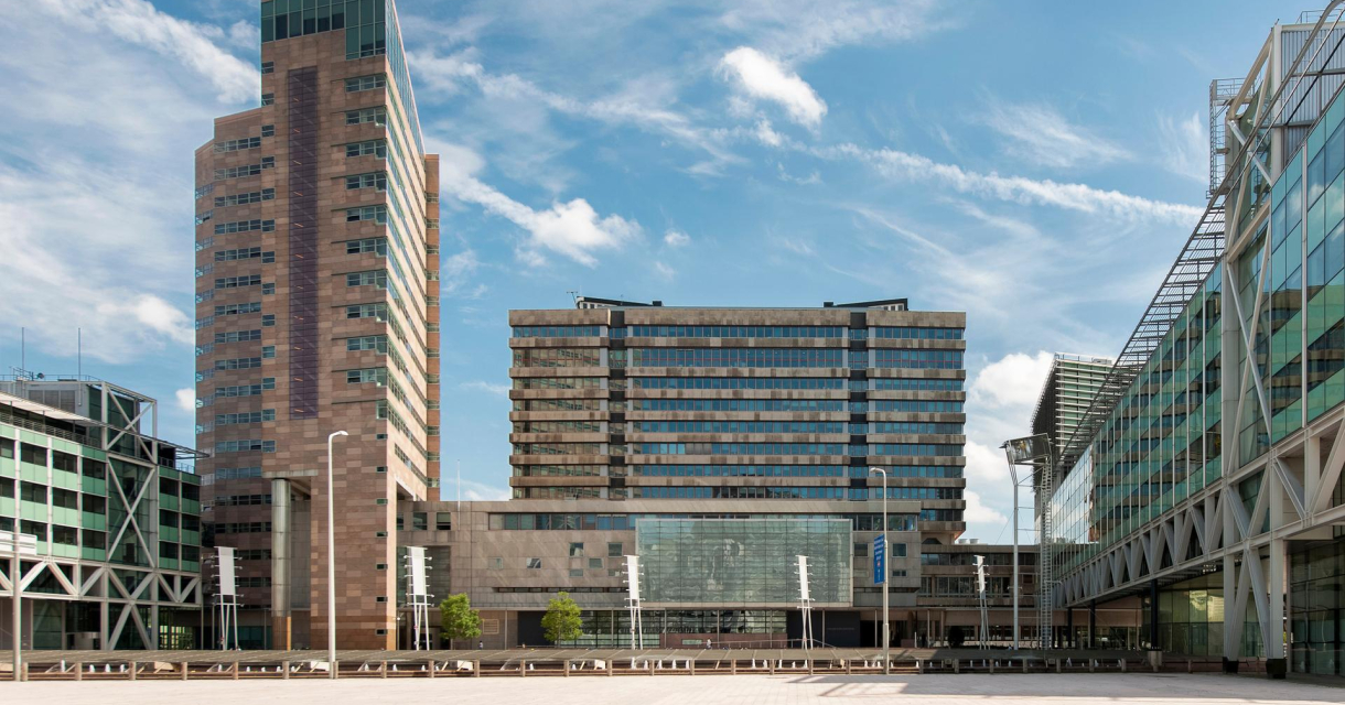 Drie moderne kantoorgebouwen met glazen gevels onder een blauwe lucht. Drie moderne kantoorgebouwen met glazen gevels onder een blauwe lucht.