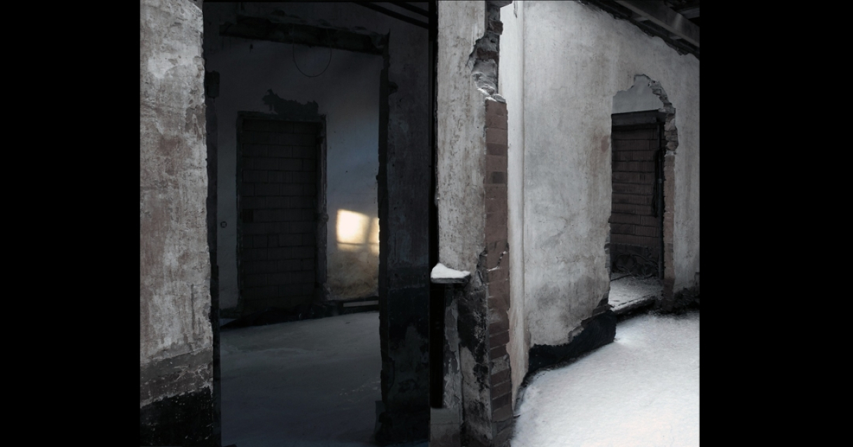 A dark, abandoned room with light coming through an opening.