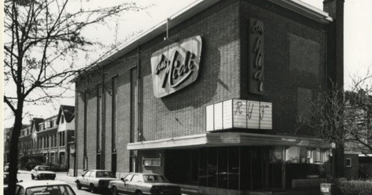 Zwart-wit foto van oud bioscoop Du Midi met neonreclame in Den Haag.