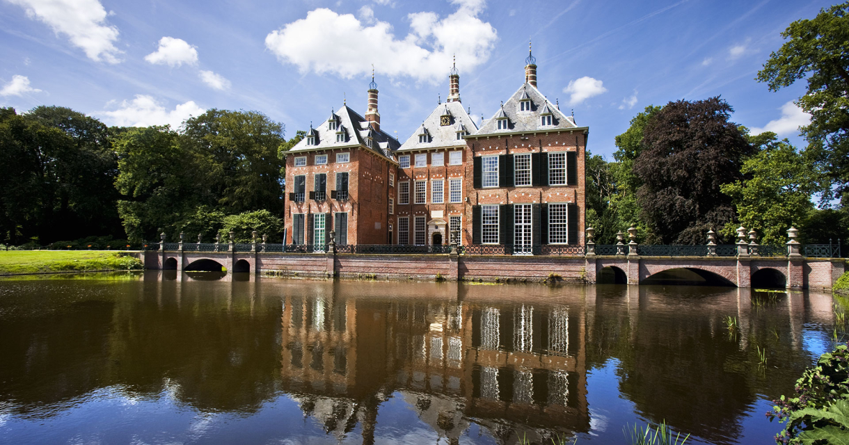 Een historisch gebouw met een spiegeling in het water.
