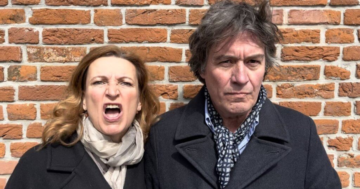 Een vrouw schreeuwt van woede naast een man die serieuze blik heeft.