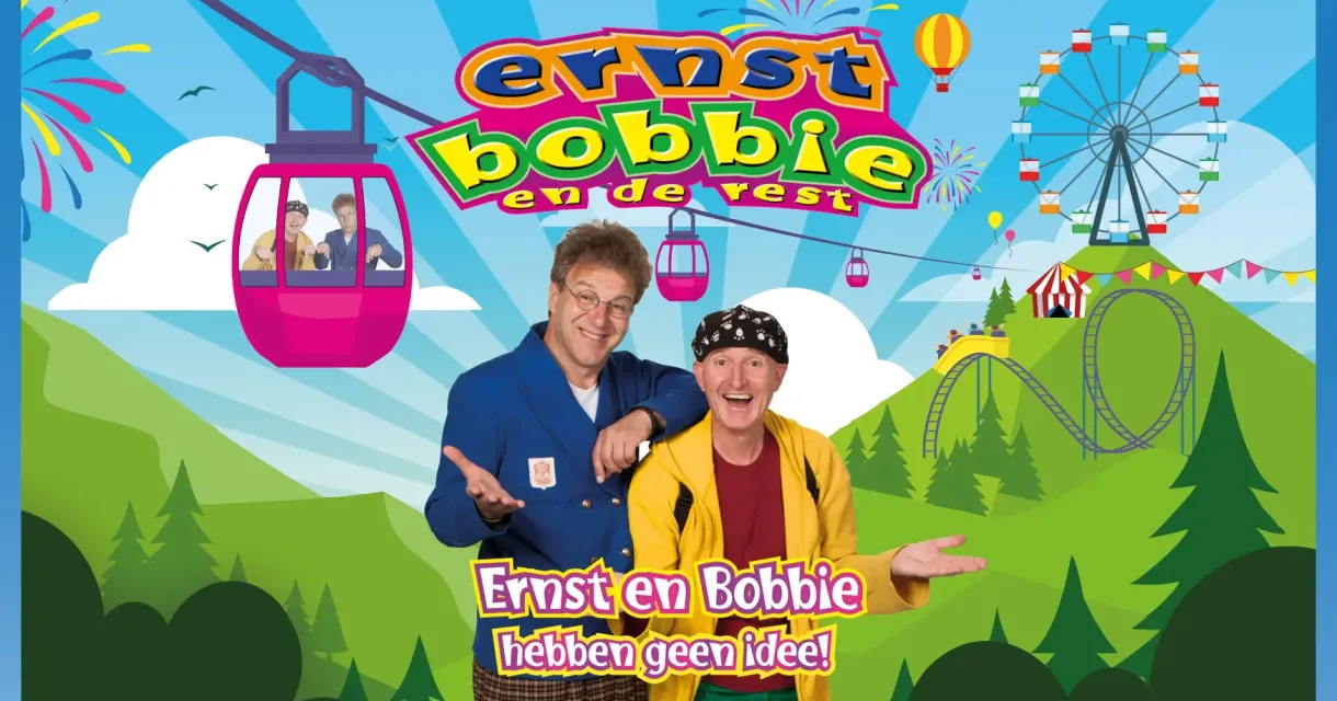Ernst en Bobbie staan lachen voor een pretparklandschap.