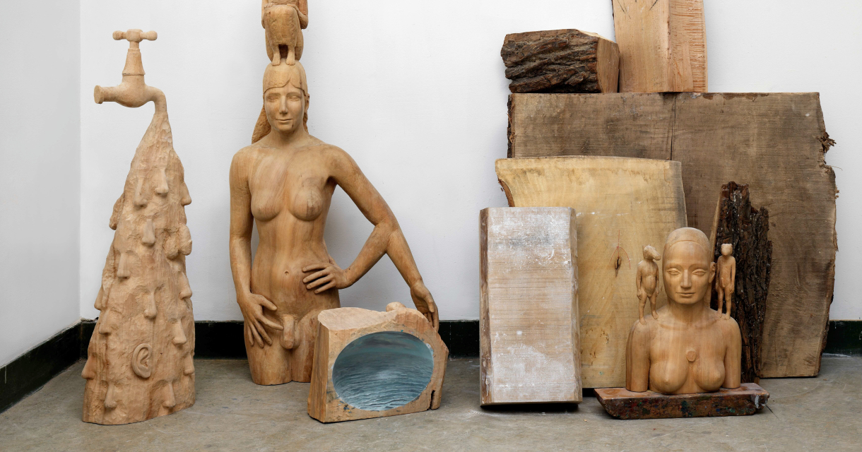 Différentes sculptures en bois contre un mur.