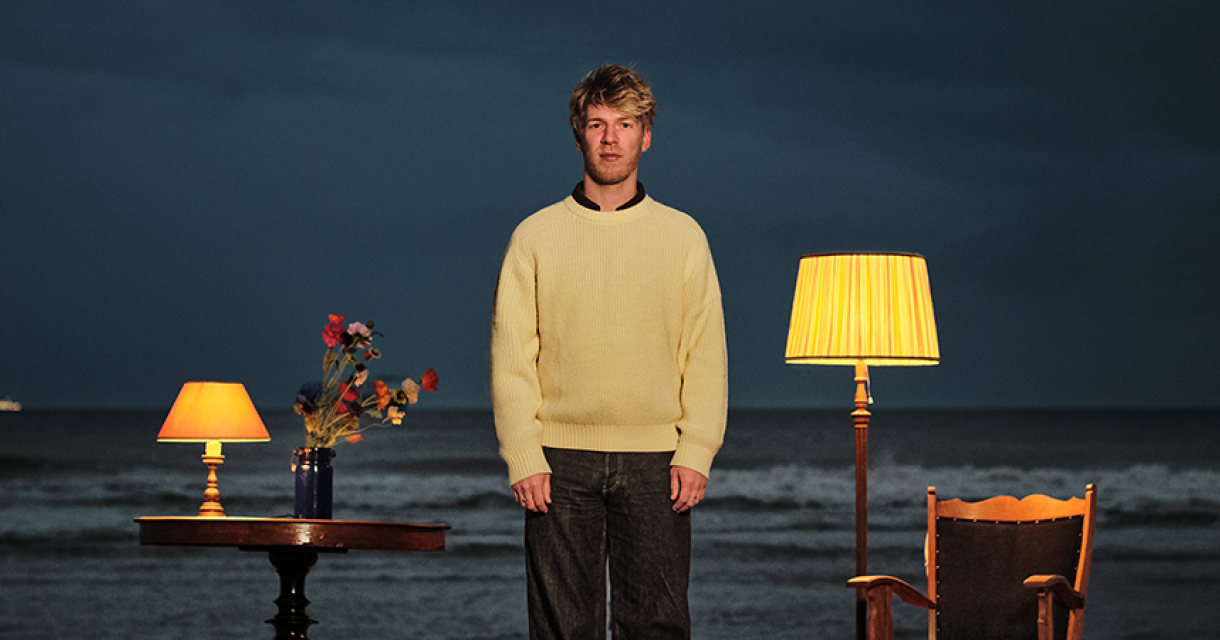 Fenster staat bij de zee met een tafel en lampen.