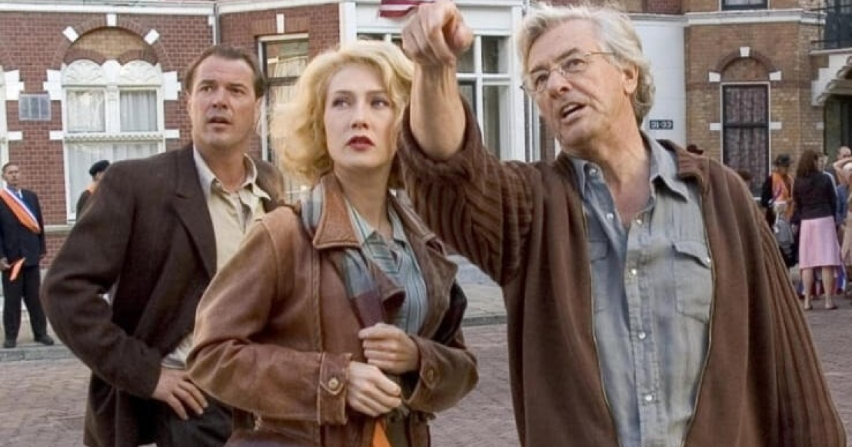 Filmstad Den Haag. Drie mensen staan op straat en kijken omhoog.
