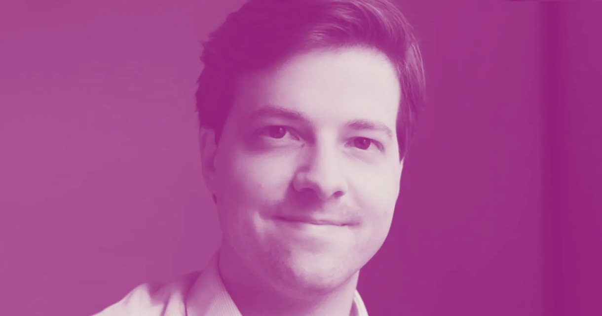 Een man met een glimlach op een paarse achtergrond.