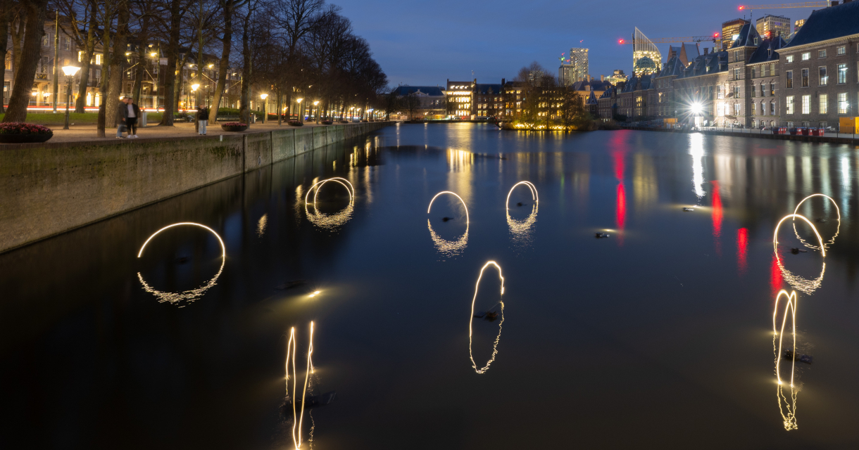 Zicht op de Hofvijver met lichtcircles en stad op achtergrond. (c) Arnaud Roelofsz