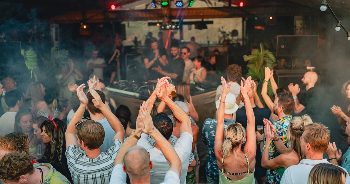 Een groep mensen danst enthousiast in een clubsetting.