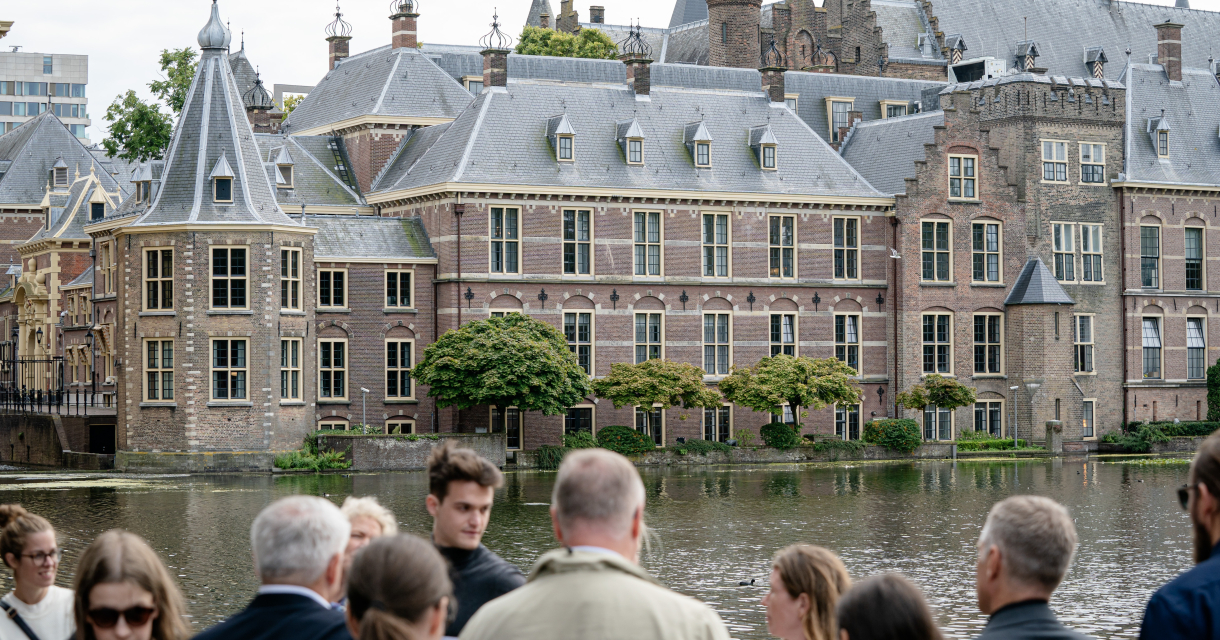 Bezoekers van het Binnenhof met de Hofvijver op de achtergrond.