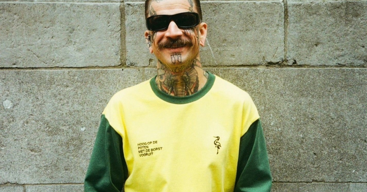 Man met tattoos poseert met een glimlach in de nieuwe collectie van Groen Gele Aderen. Man met tattoos poseert met een glimlach in de nieuwe collectie van Groen Gele Aderen.