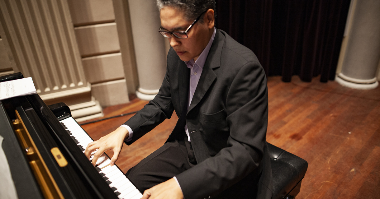 Een pianist speelt op een zwart concertvleugel.
