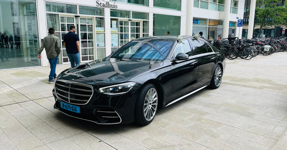 Haagse Taxi Lijn. Een zwarte Mercedes staat voor het stadhuis.