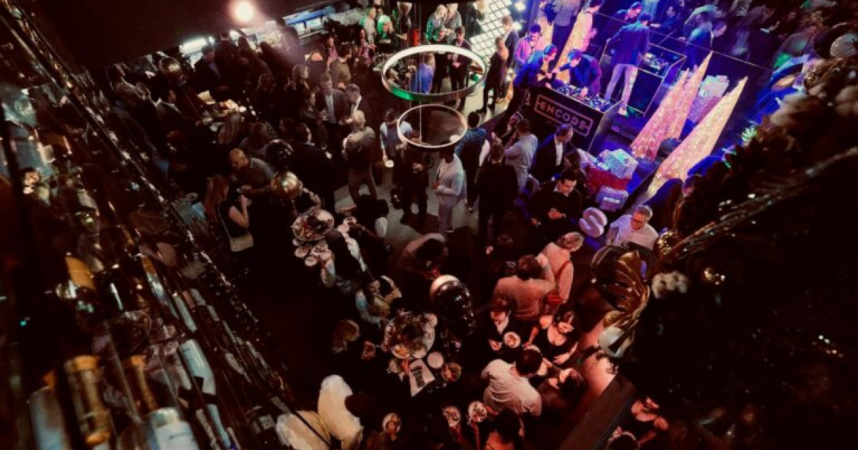 Een drukke menigte op een feest met ronde lichten.