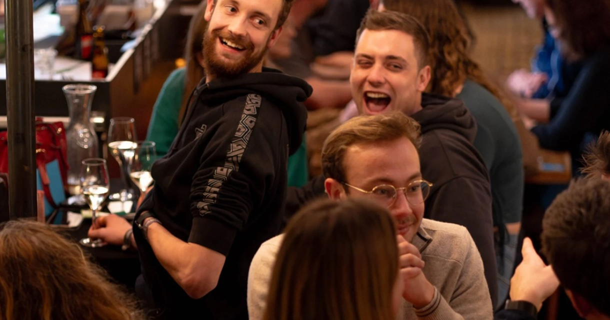 Mensen lachen en socialiseren in een druk café.