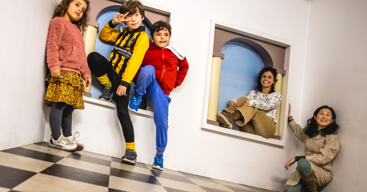 Five children and adults posing in a playful space