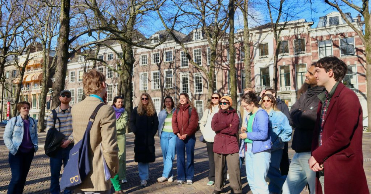 Toeristen luisteren naar een gids in een park.