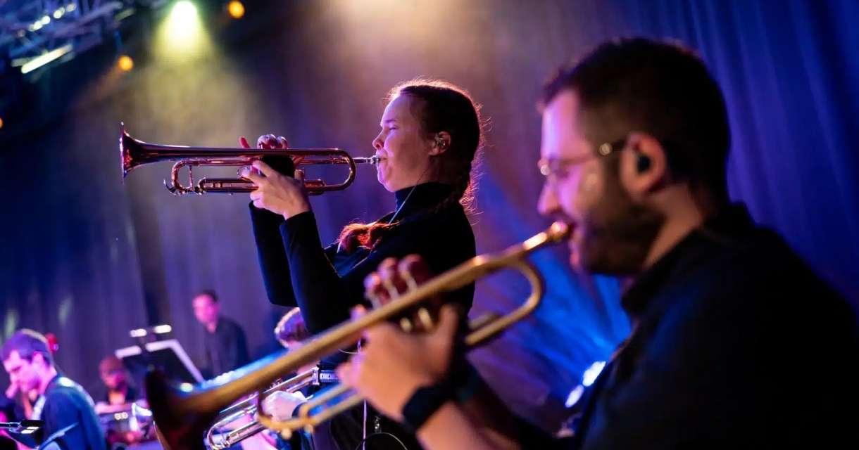 Jong Metropole – Fiesta de Verano. Twee muzikanten spelen trompet op een podium.