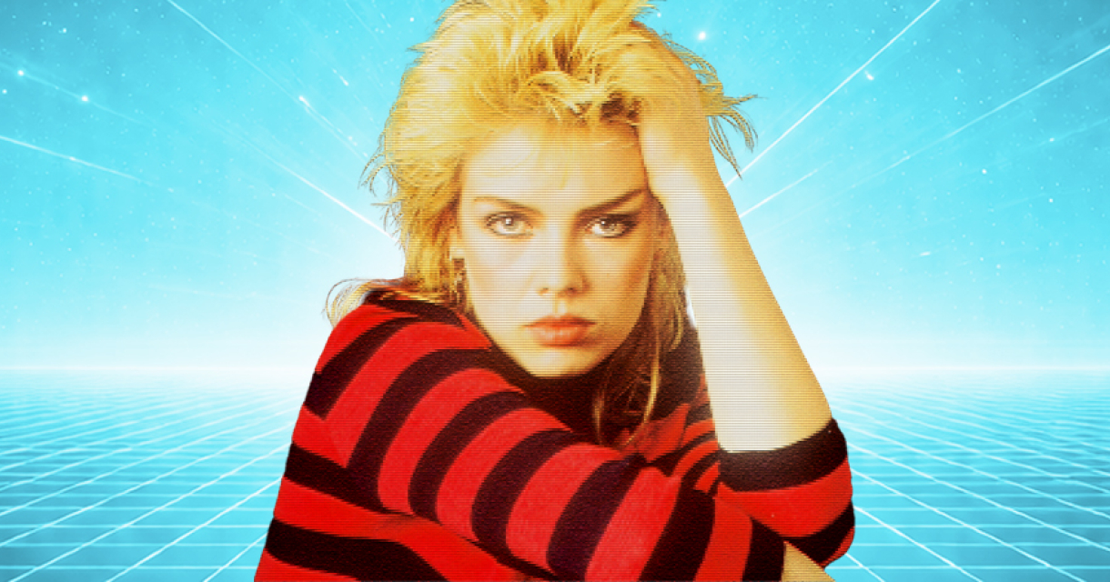 Kim Wilde in een gestreepte trui leunt met haar hoofd op haar hand.