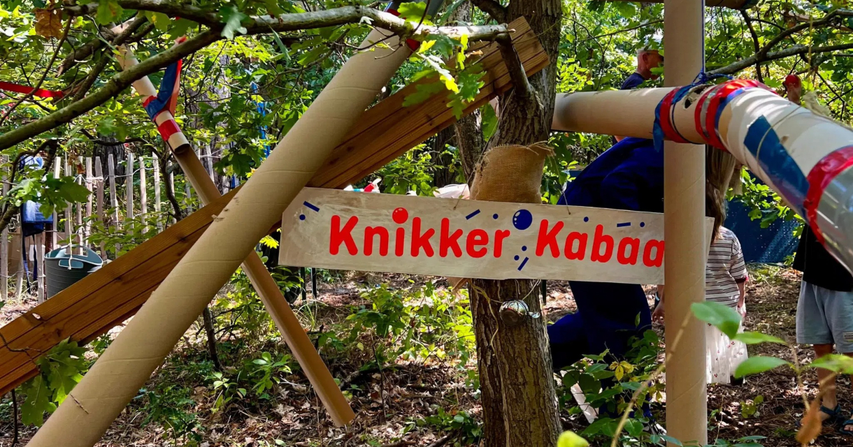 A marble run made of wood and pipes in the forest.