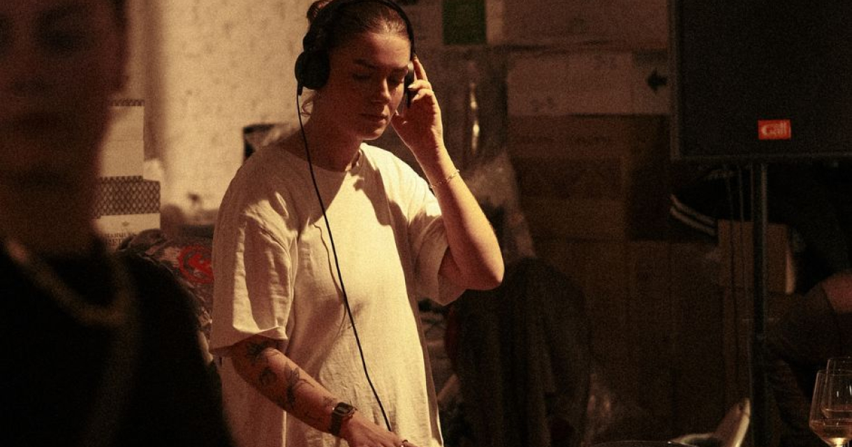 Een DJ draait op een draaitafel in een sfeervolle setting in een tattooshop.