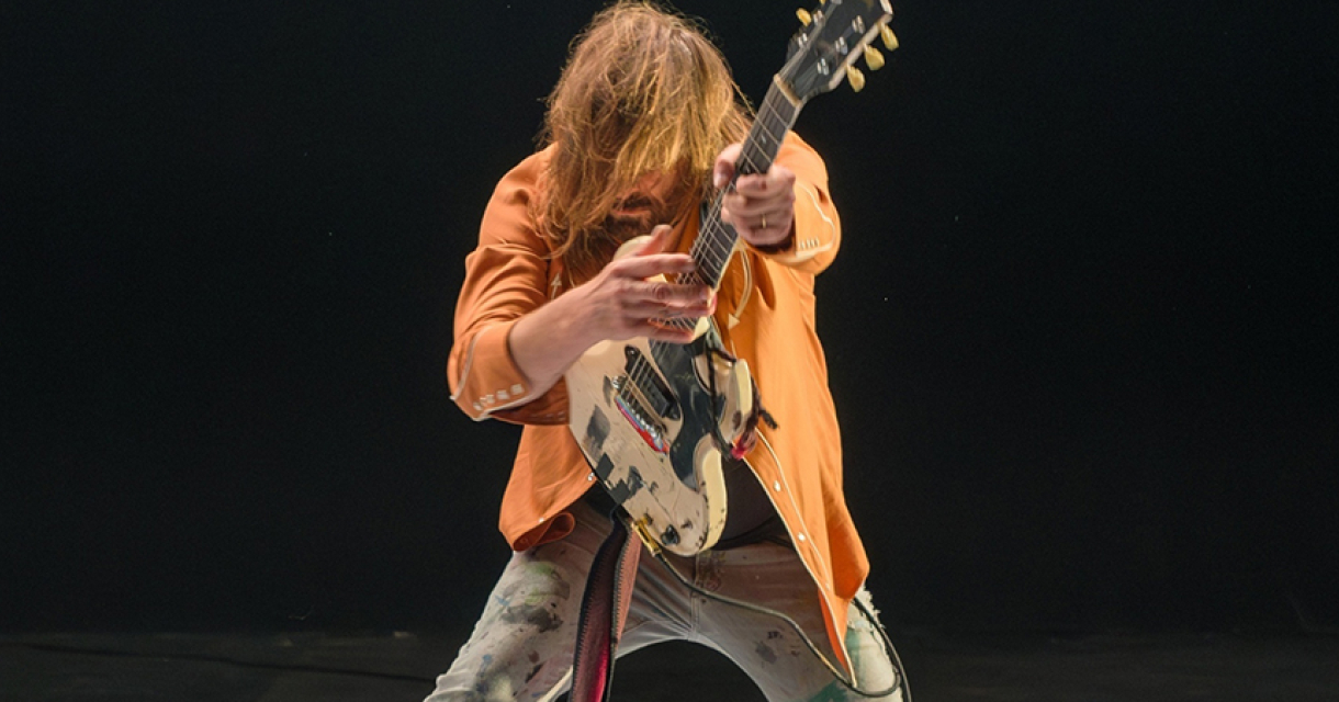 Gitarist in actie. Man speelt gitaar met energie en passie