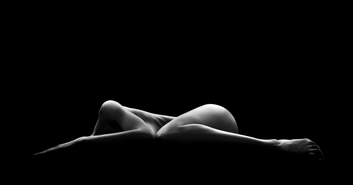 Half liggend naakt lichaam in monochrome belichting