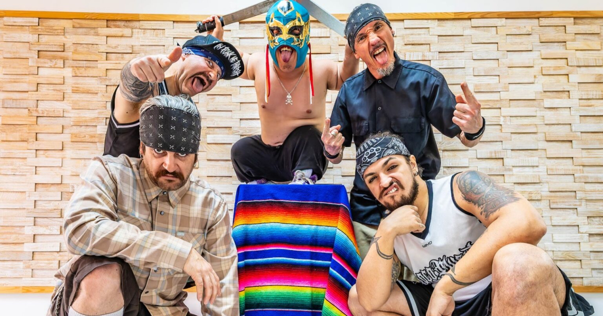 Groep mannen in kleurrijke outfits poseren met een kleurrijk deken en een zwaard.